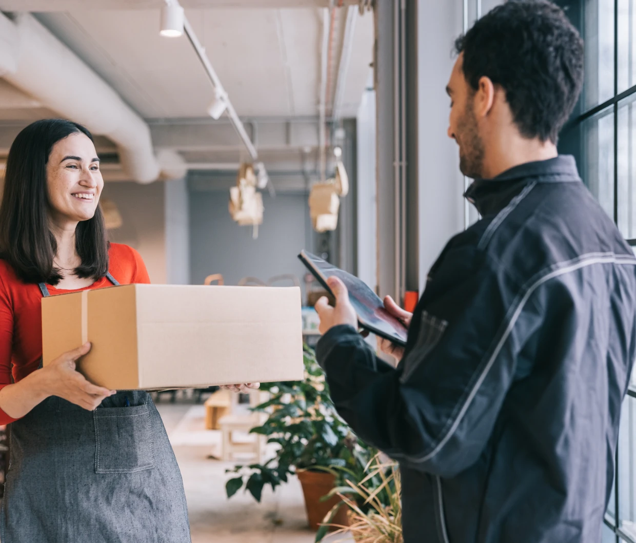 Smiling woman accepts delivery indoors