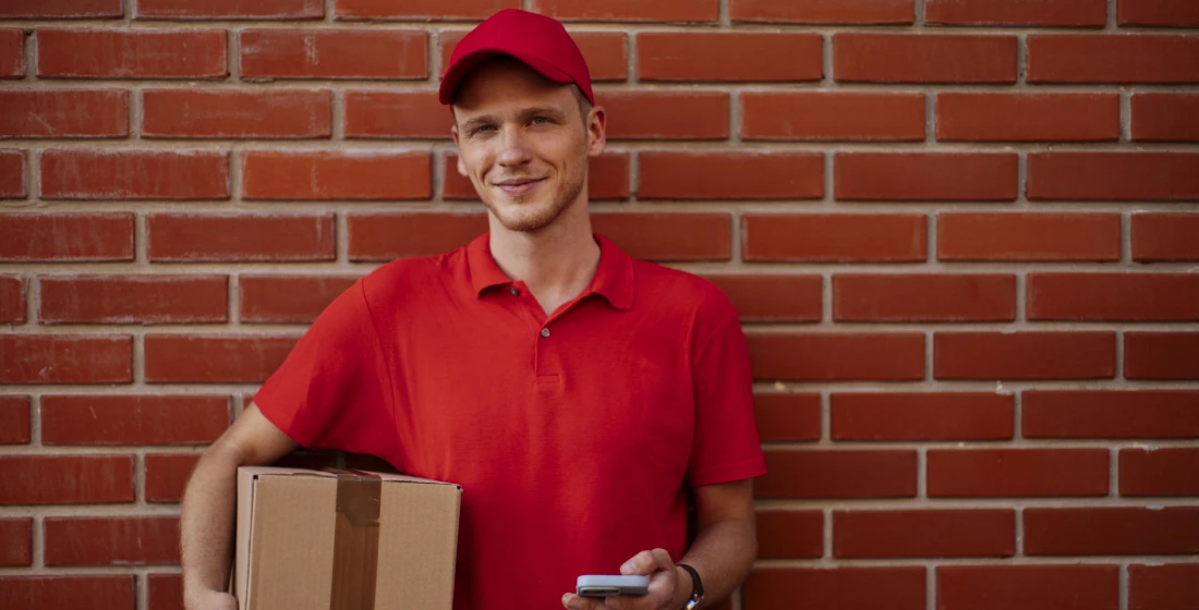Delivery worker against brick wall